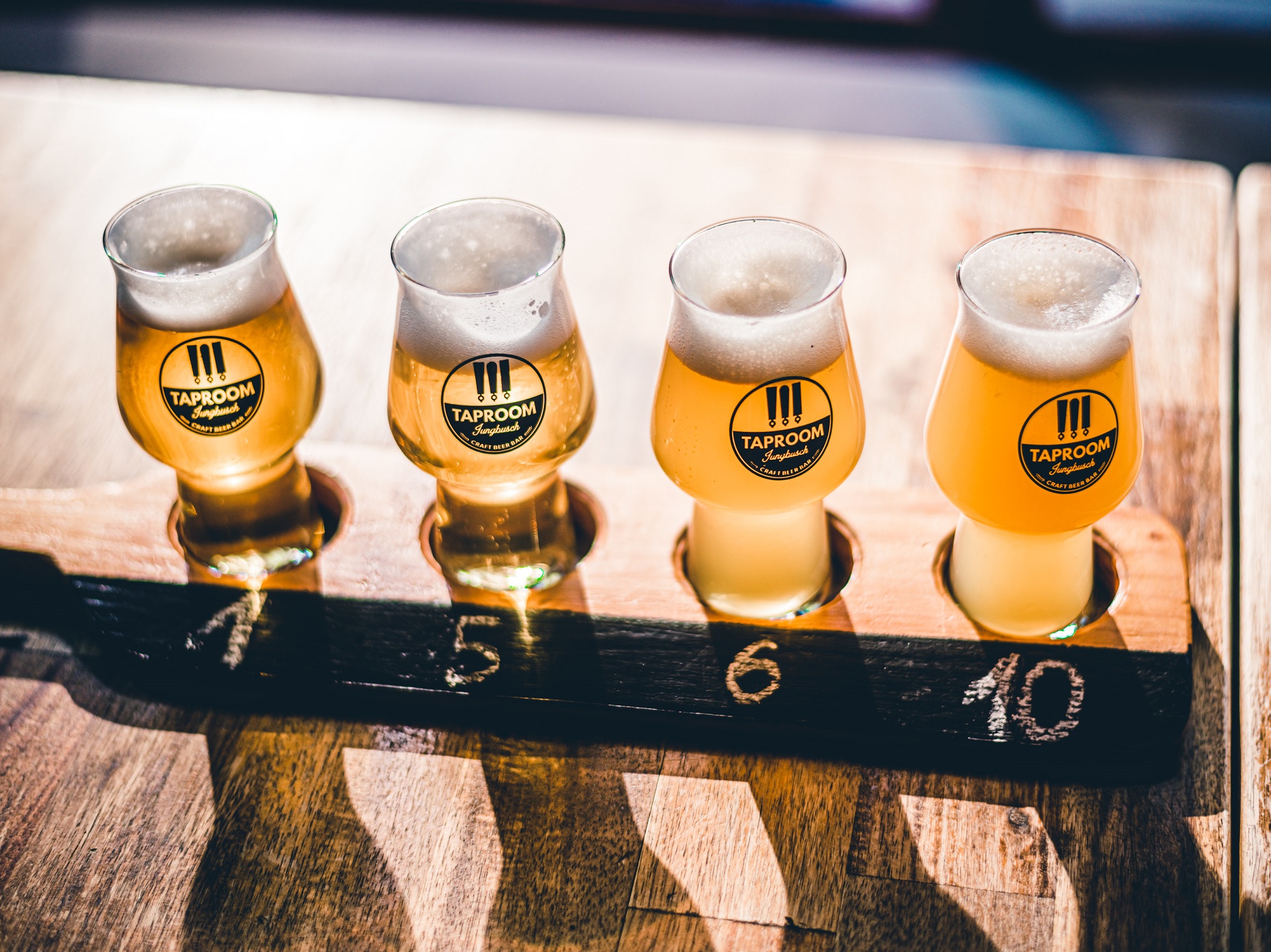 4 glasses with beer on a wooden paddle